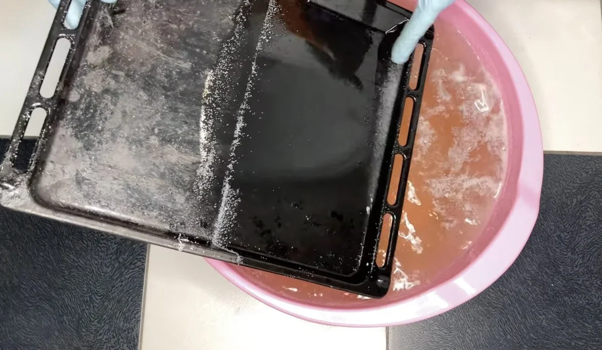 Starý, zašpiněný plech z trouby září jako zrcadlo: Posypte ho 2 lžícemi a zalijte horkou vodou